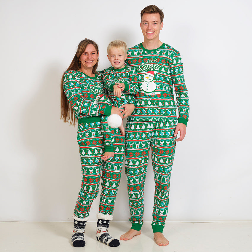 Eine Familie in einem grünen Weihnachtspyjama mit Schneemann.